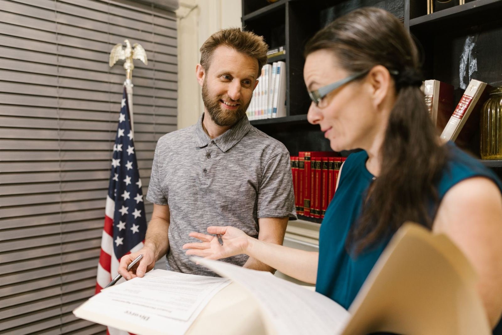 A man and a woman review a printed document together at a desk
