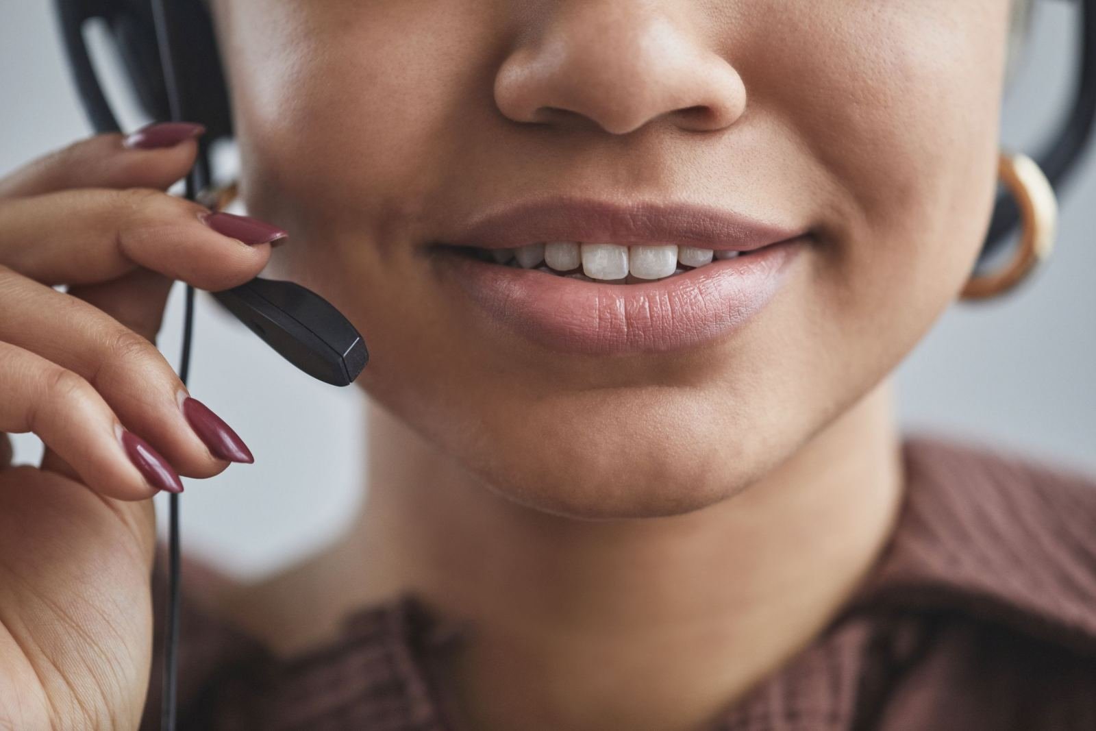 A close-up of a person wearing a headset and smiling