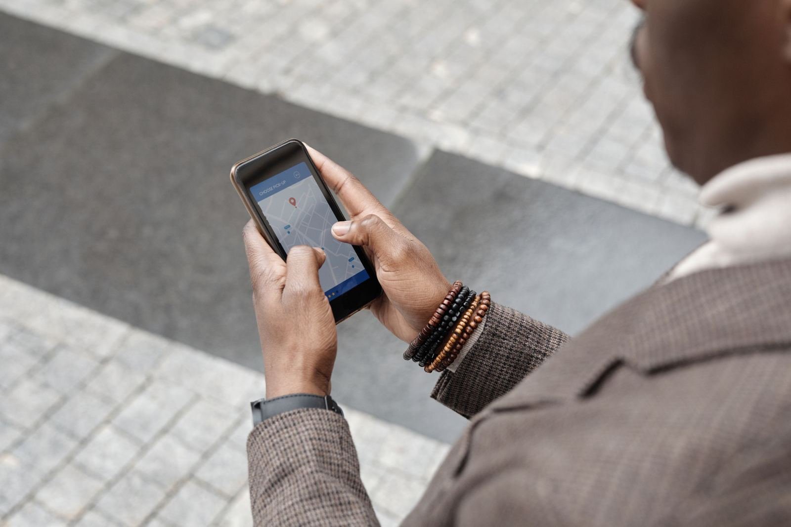 Someone holds a phone with a map app outside.