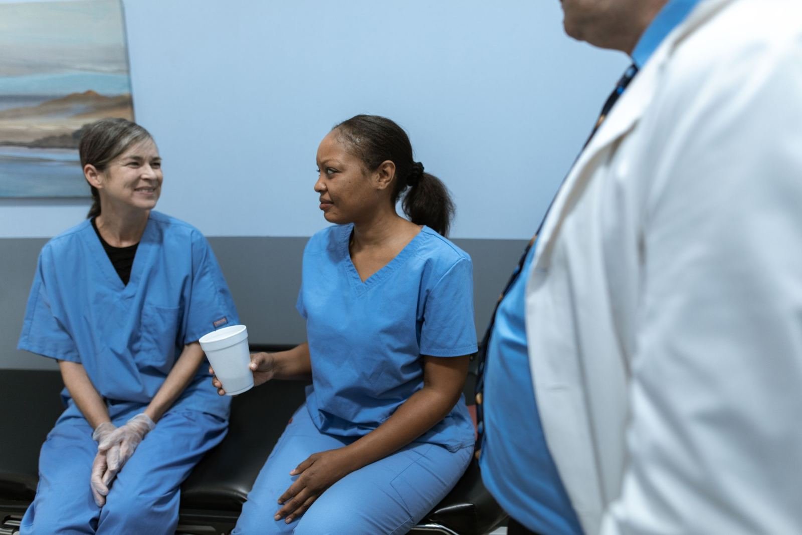 Clinic workers in blue clothes chat during a visit.
