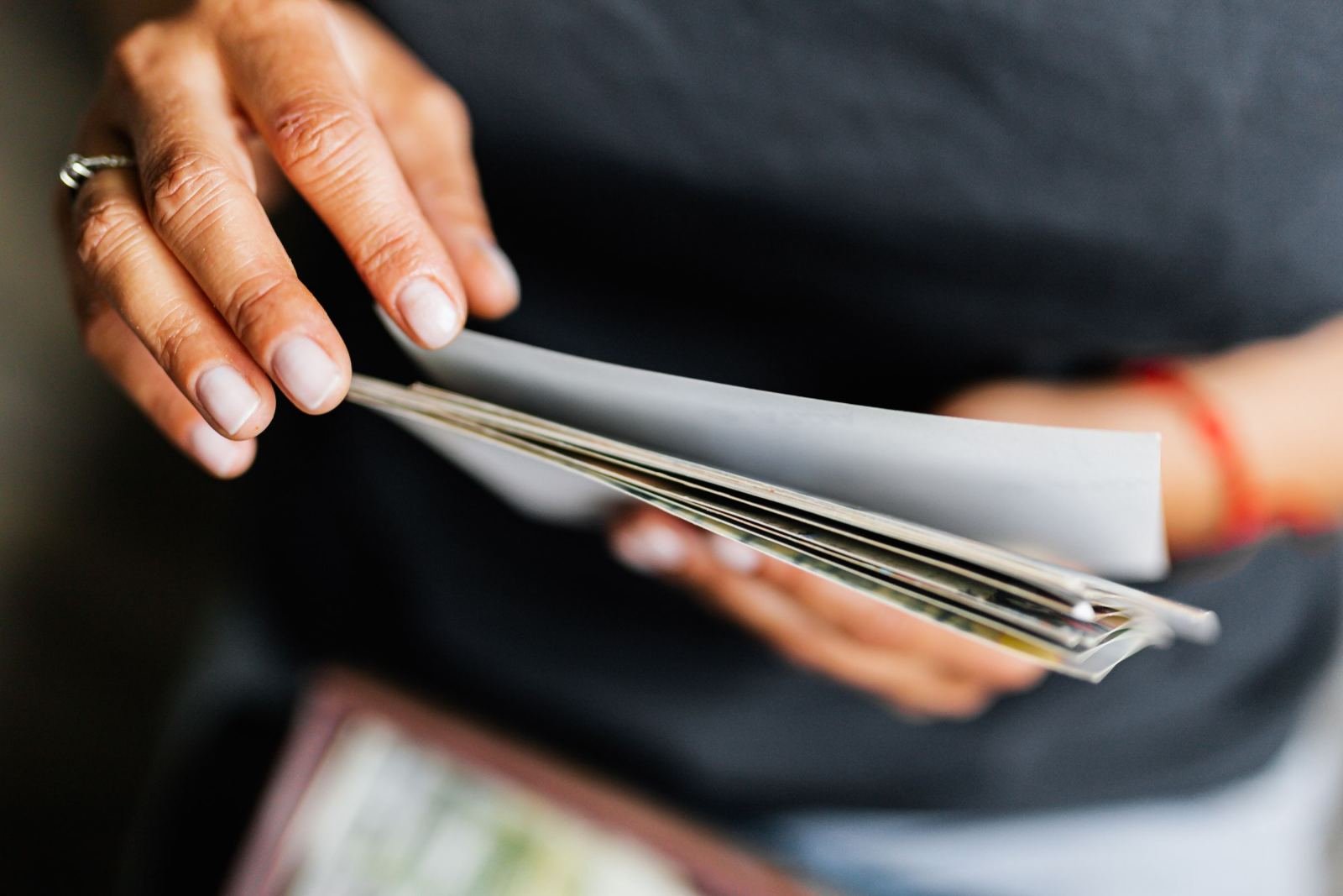 Close-up of a person's hands flipping through a stack of papers