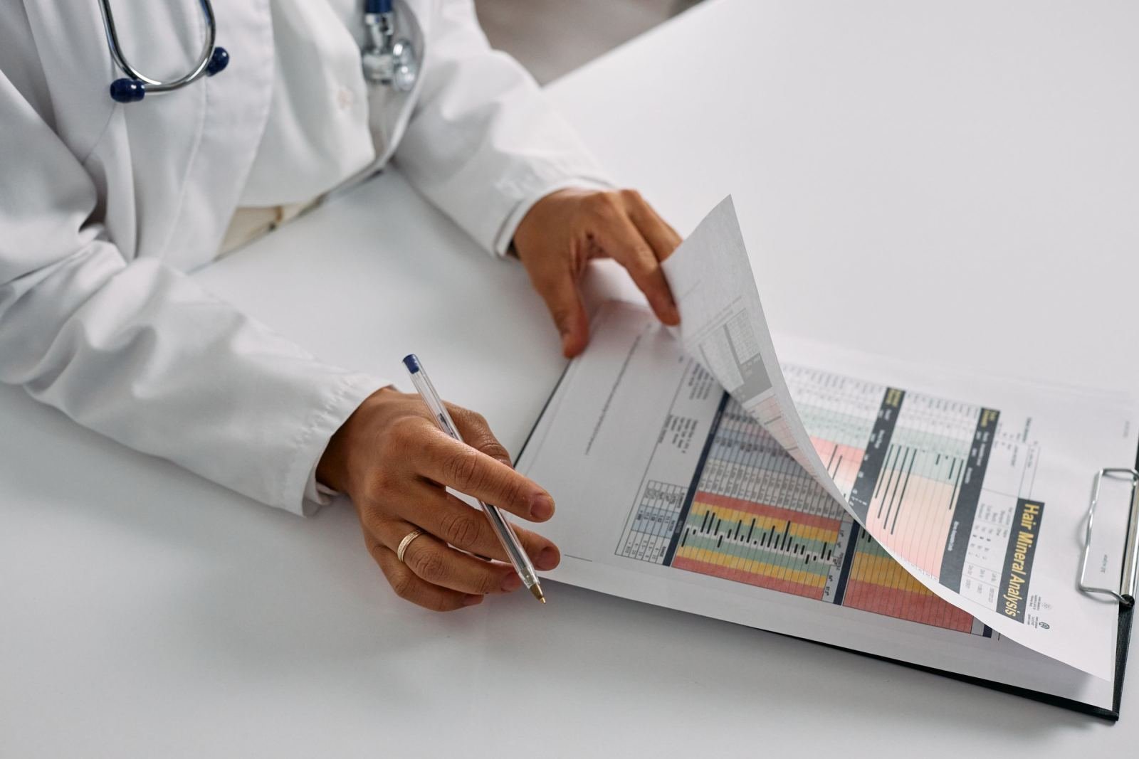 A healthcare provider in a white coat reviews a medical report on a clipboard