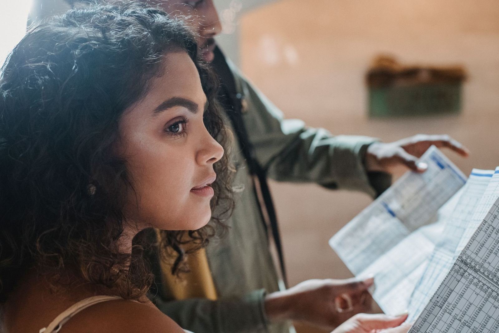 A man and a woman look at a paper together.