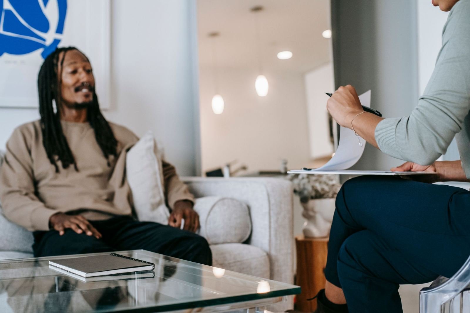 A man talks with a counselor who is taking notes on a clipboard